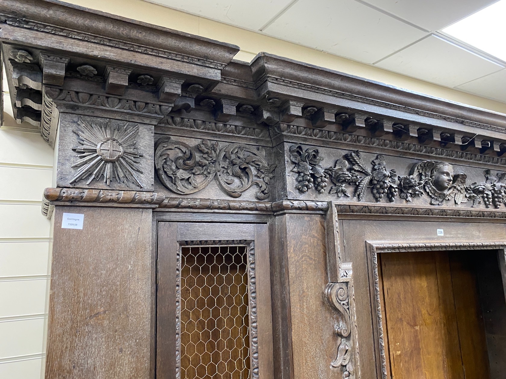 A large 19th century oak breakfront cabinet, with a finely carved frieze, length 280cm, depth 47cm, height 227cm